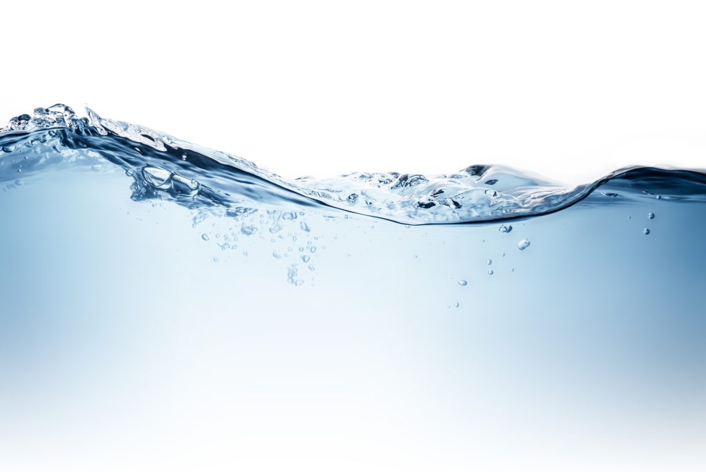 Crystal-clear water flowing gently with visible ripples, representing clean, healthy drinking water and effective home water treatment solutions.
